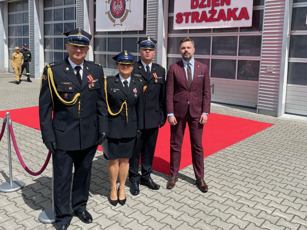 Wspólne zdjęcie przedstawicieli PSP wraz  Pawłem Graczykiem na tle budynku Straży