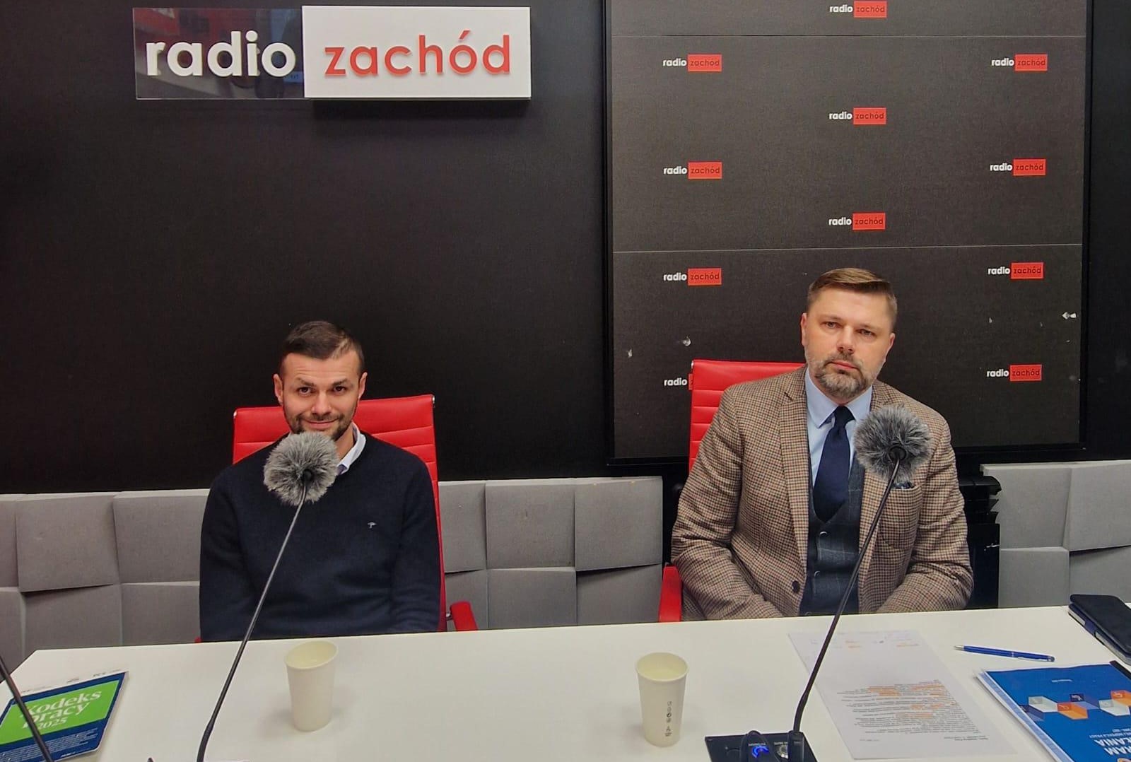 Zdjęcie w studio radiowym, przedstawiciele Okręgu siedzą przed mikrofonami w studio