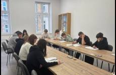 Uczestnicy konkursu siedzą w ławkach i rozwiązują test