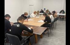 Uczestnicy konkursu siedzą w ławkach i rozwiązują test