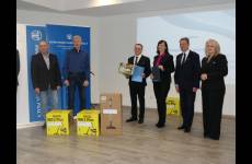 Laureaci konkursu Okręgowego Inspektoratu Pracy. Przedstawiciele pracodawców stoją na scenie, w dłoniach trzymają otrzymane grawertony.