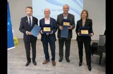 Laureaci konkursu Okręgowego Inspektoratu Pracy. Przedstawiciele pracodawców stoją na scenie, w dłoniach trzymają otrzymane grawertony.