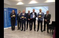 Laureaci konkursu Okręgowego Inspektoratu Pracy. Przedstawiciele pracodawców stoją na scenie, w dłoniach trzymają otrzymane grawertony.