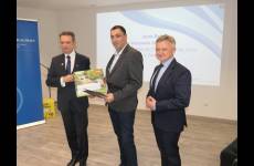 Laureaci konkursu Okręgowego Inspektoratu Pracy. Przedstawiciele pracodawców stoją na scenie, w dłoniach trzymają otrzymane grawertony.